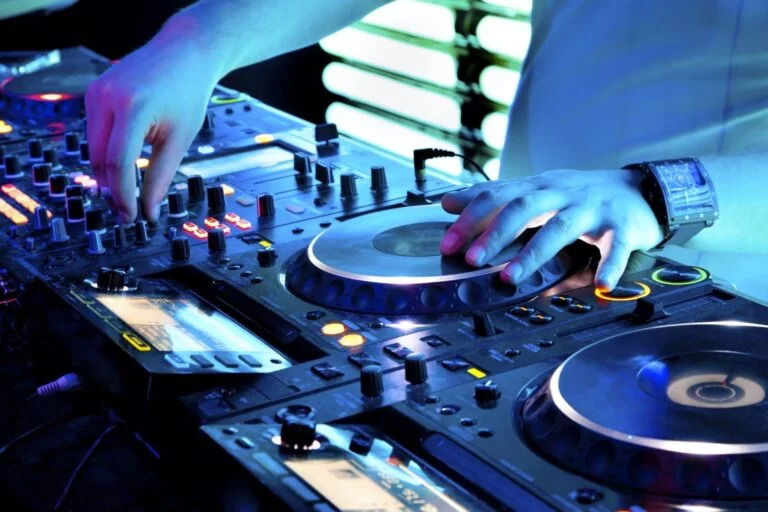 Close-up of professional DJ hands manipulating digital turntable controllers in Boca Raton, FL