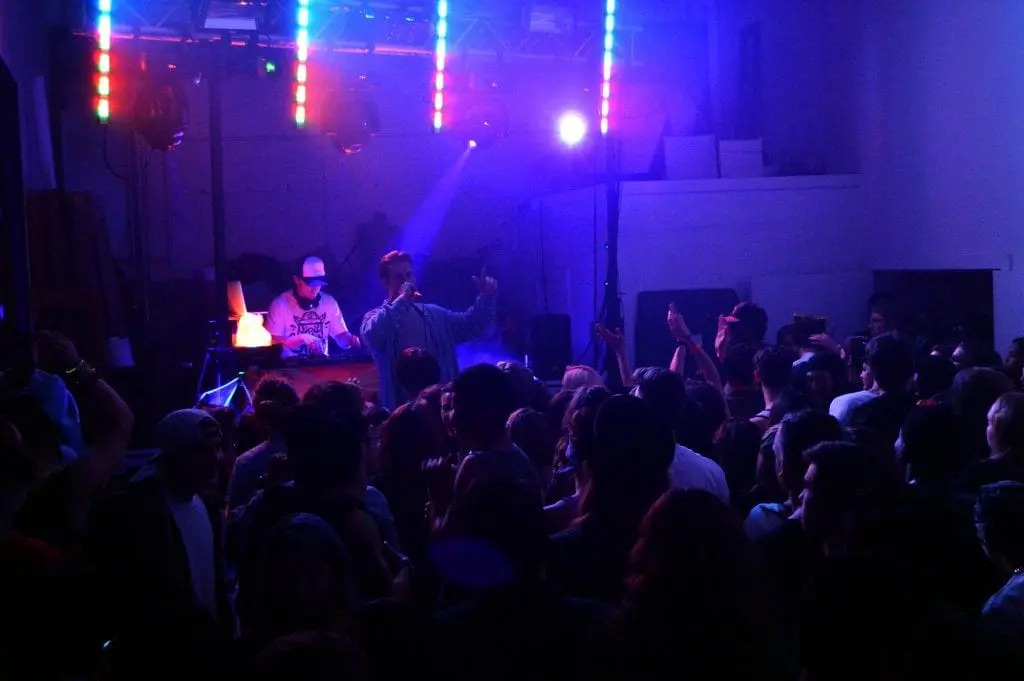 Live DJ performance with vocalist on stage under neon lighting in Boca Raton, FL