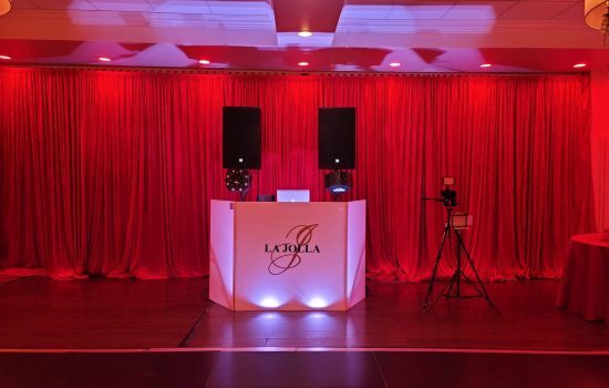 Professional DJ booth setup featuring La Jolla branding, red drapes, sound speakers, and lighting in Fort Lauderdale, FL